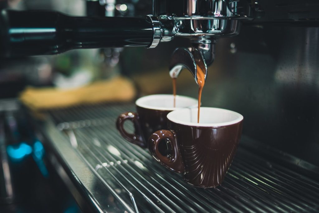 Close-up of Espresso Coffee Maker dispensing into 2 Espresso Cups